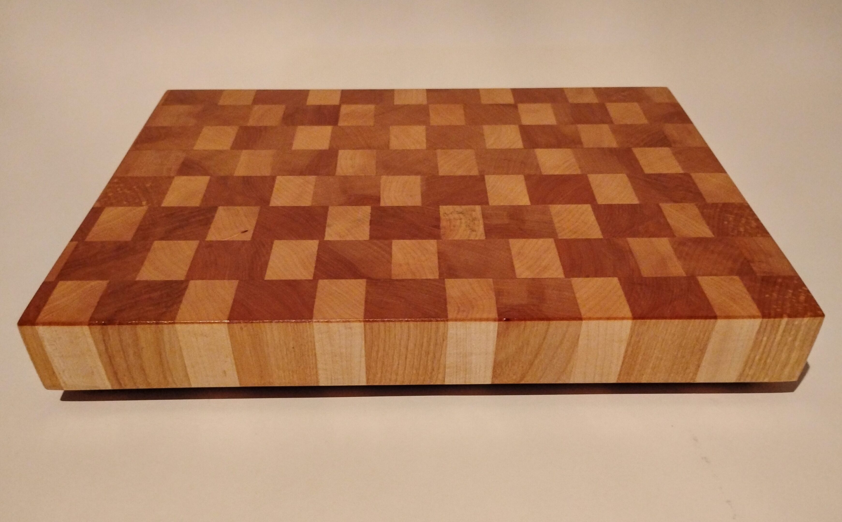 Wooden cutting board with a checkered pattern.