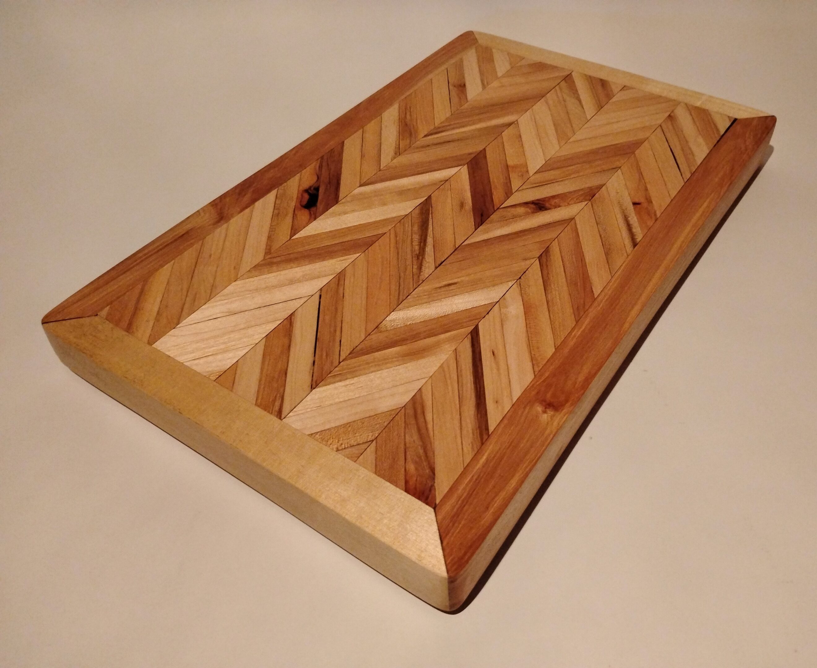 Wooden cutting board with a chevron pattern.