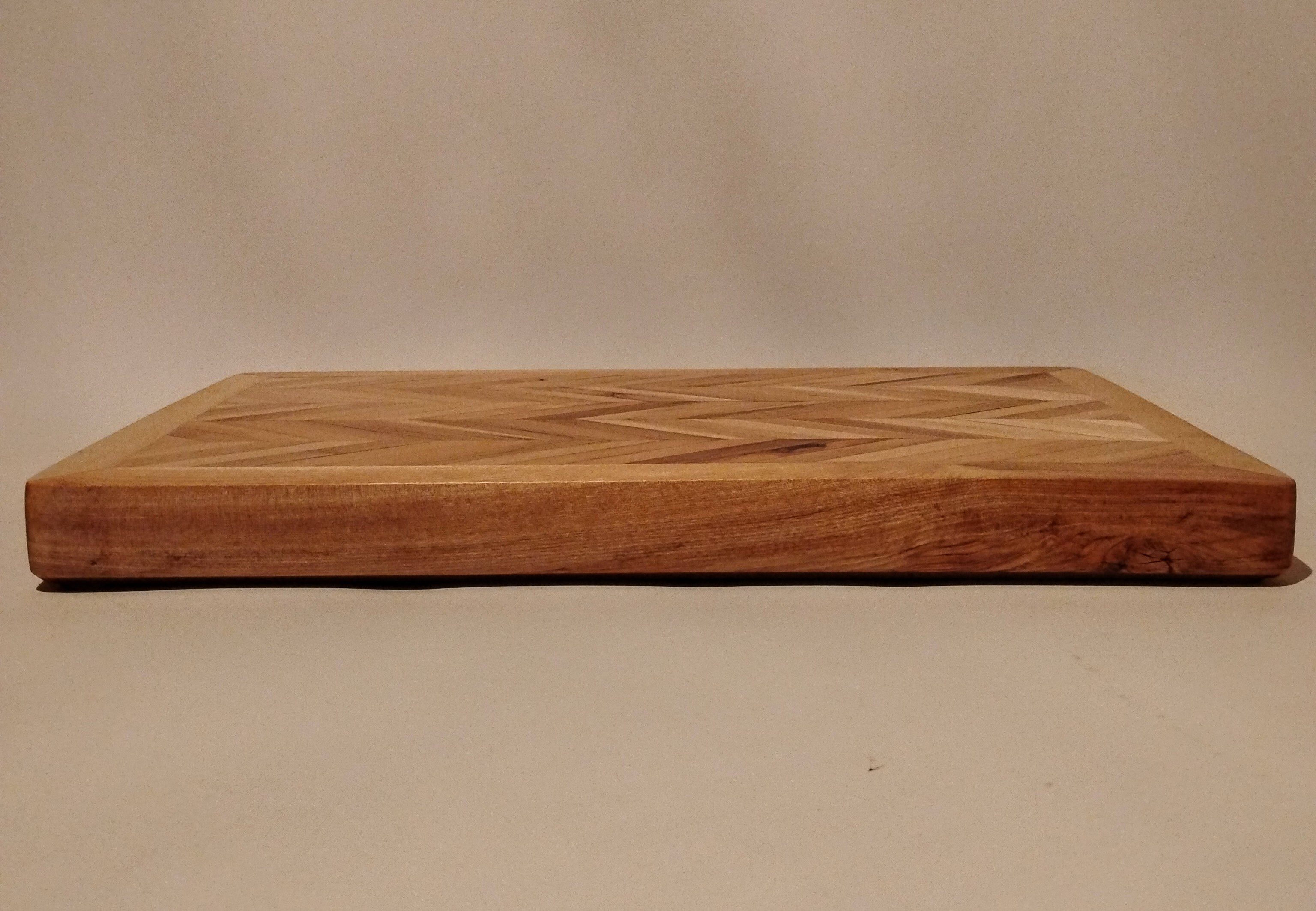 Close-up of a wooden cutting board on a neutral surface.