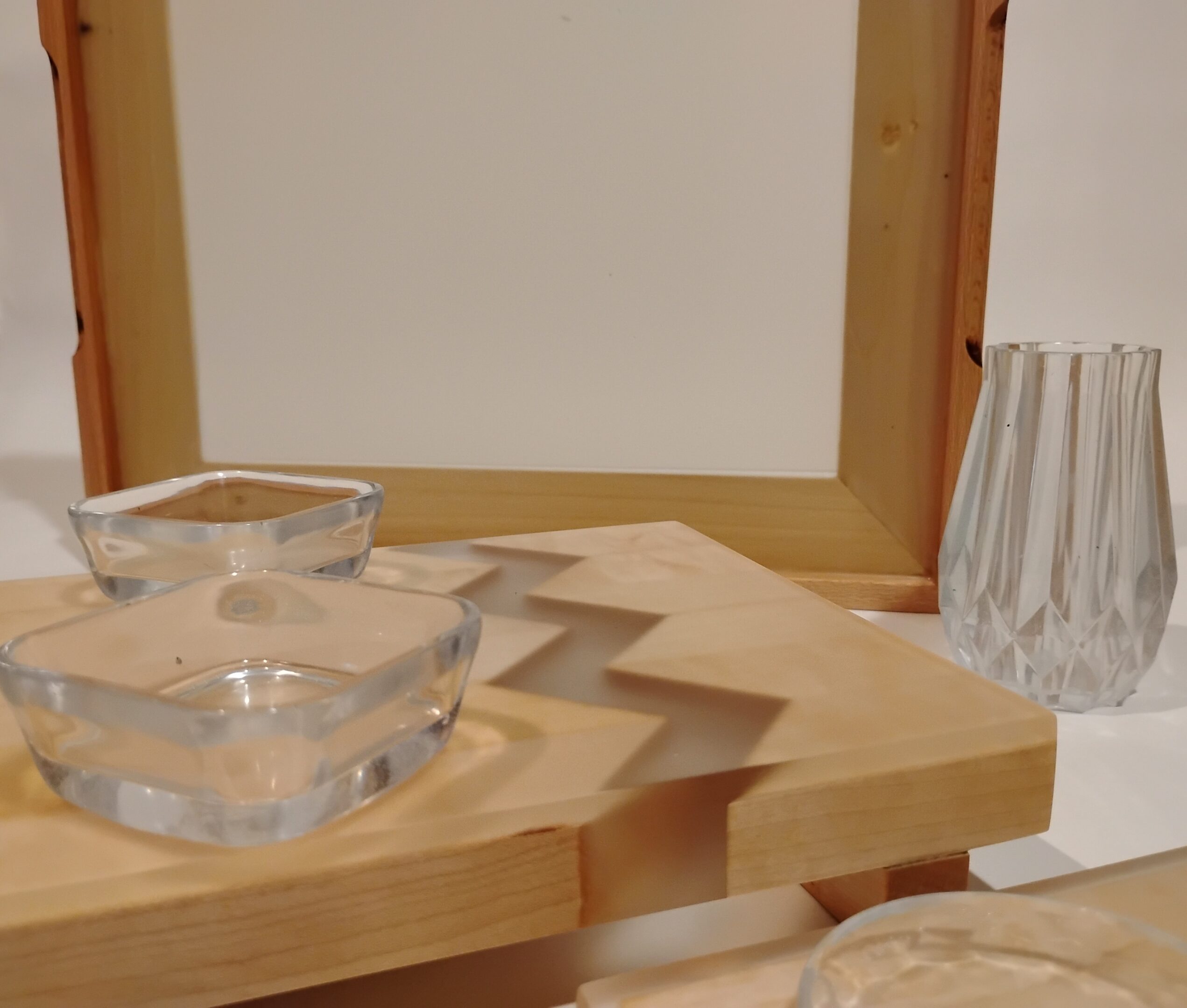 Wooden zigzag shelf with glass candle holders.