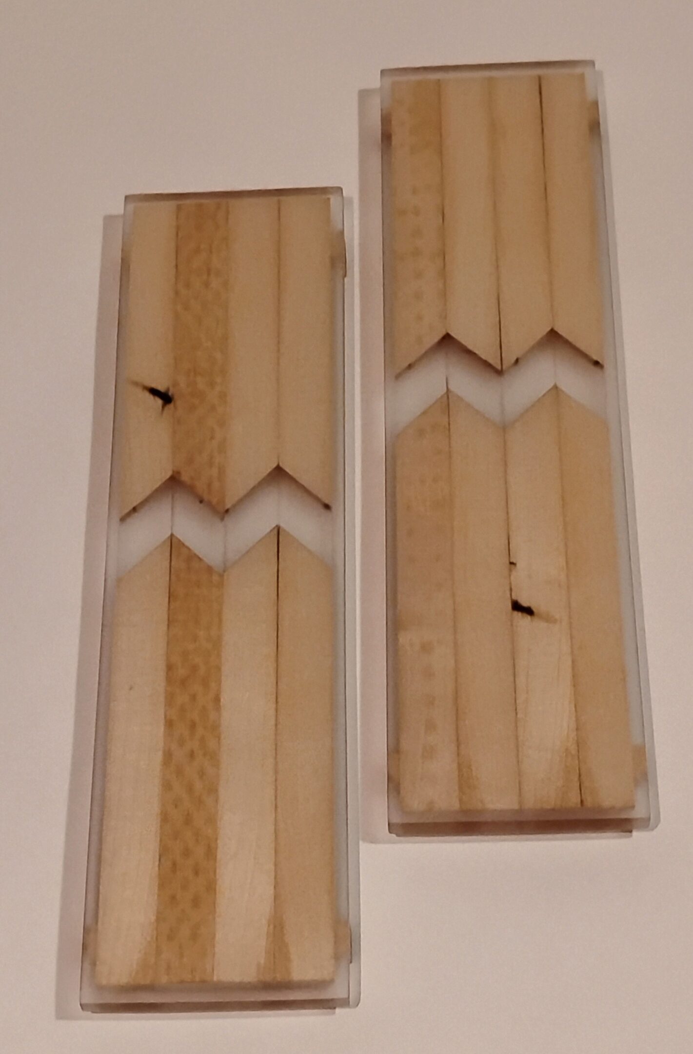 Two wooden cricket bats with visible grain and minor damage marks.