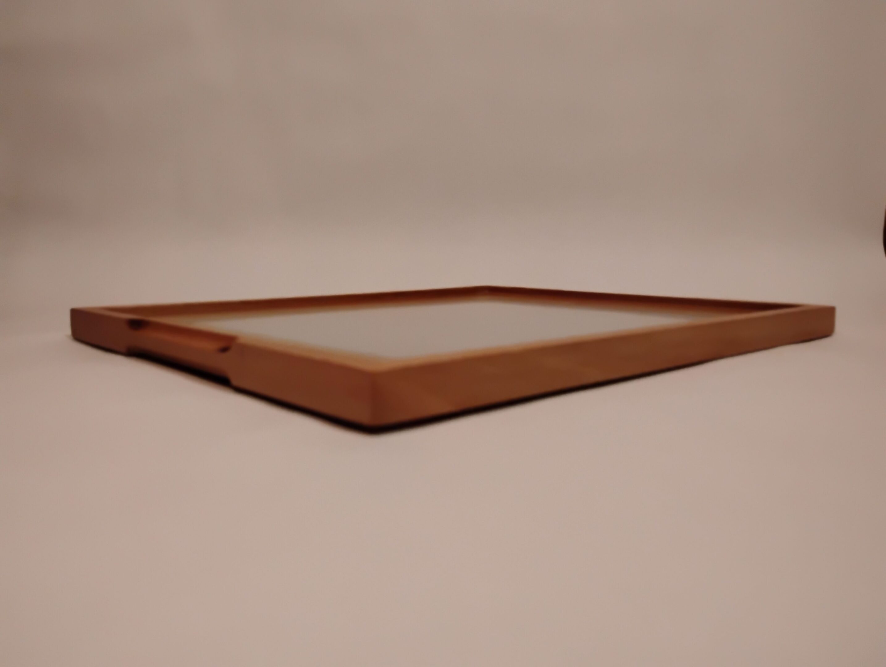 Close-up of a wooden picture frame lying on its side.