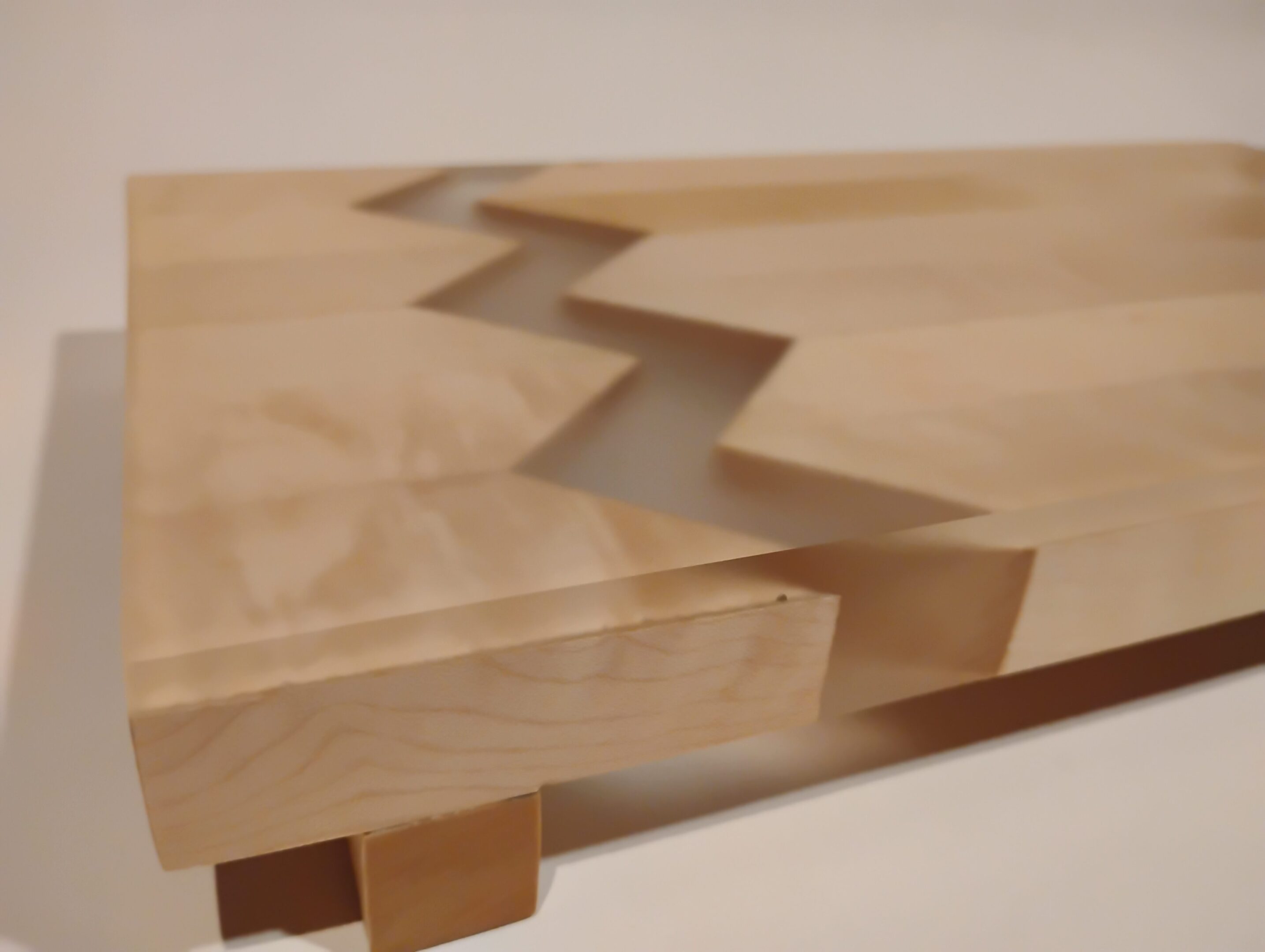 Close-up of a wooden joint with a zigzag dovetail pattern.