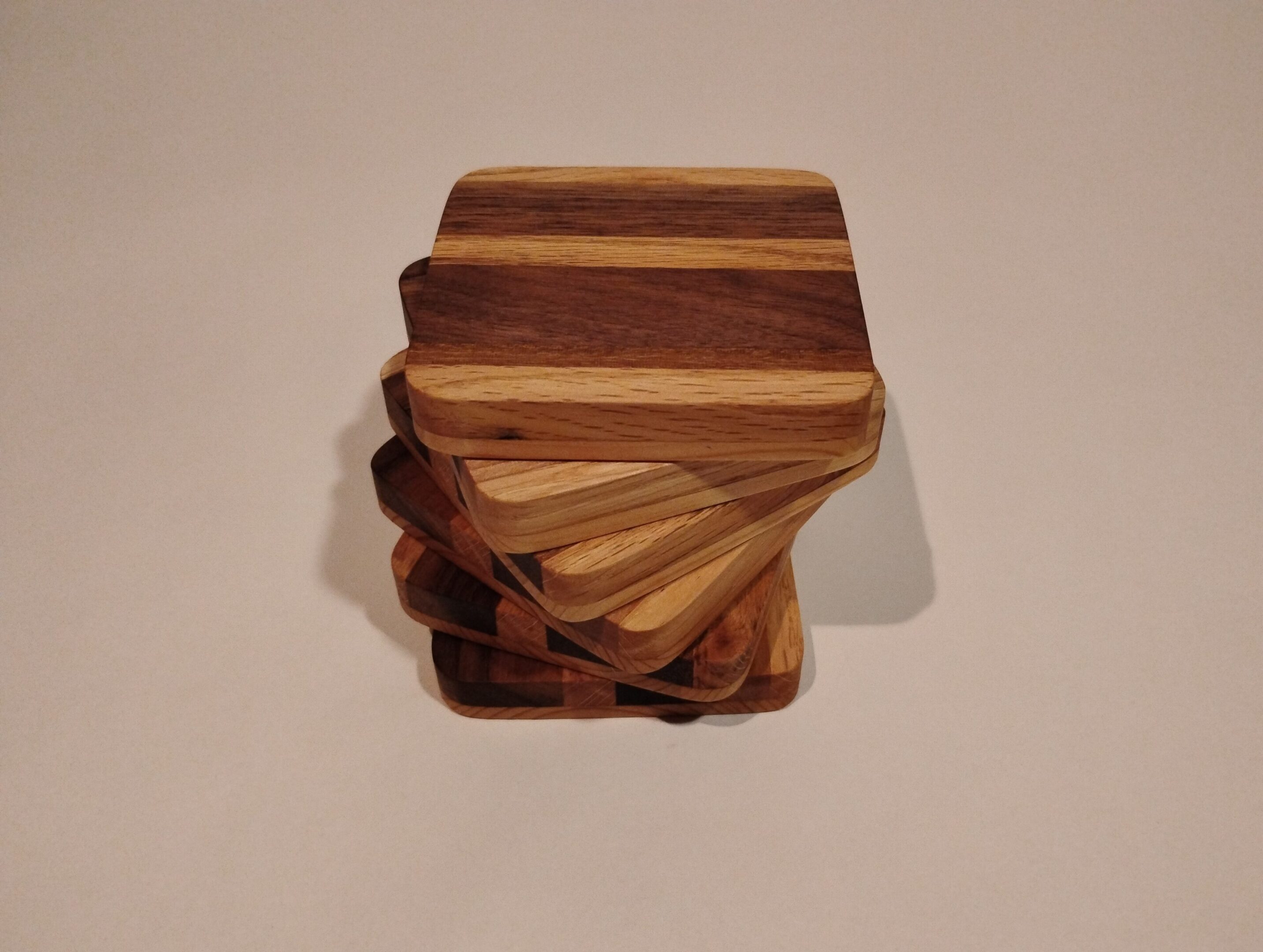 Stack of wooden coasters with striped patterns.