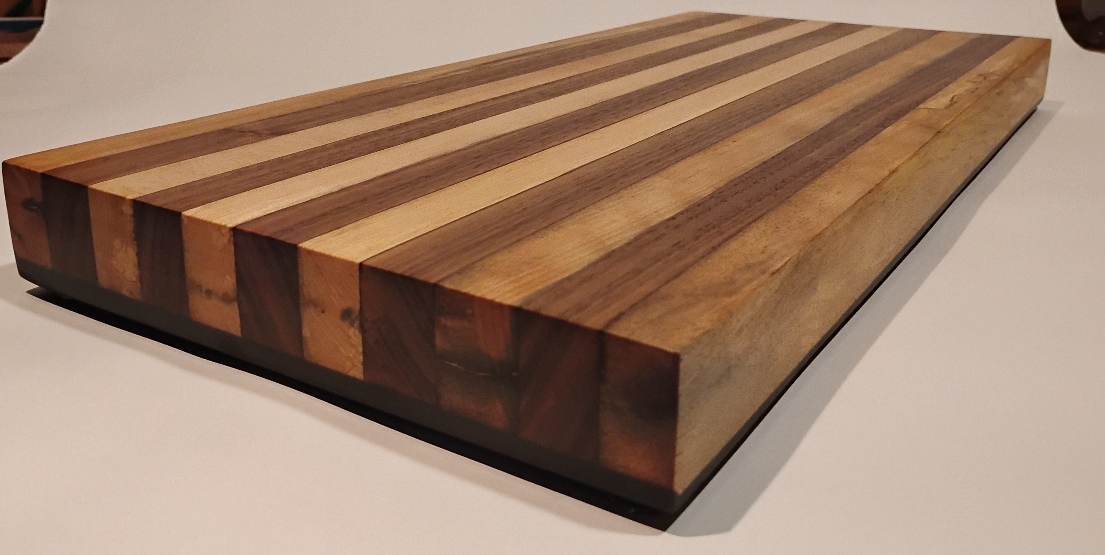 Close-up of a striped wooden cutting board with contrasting wood grains.