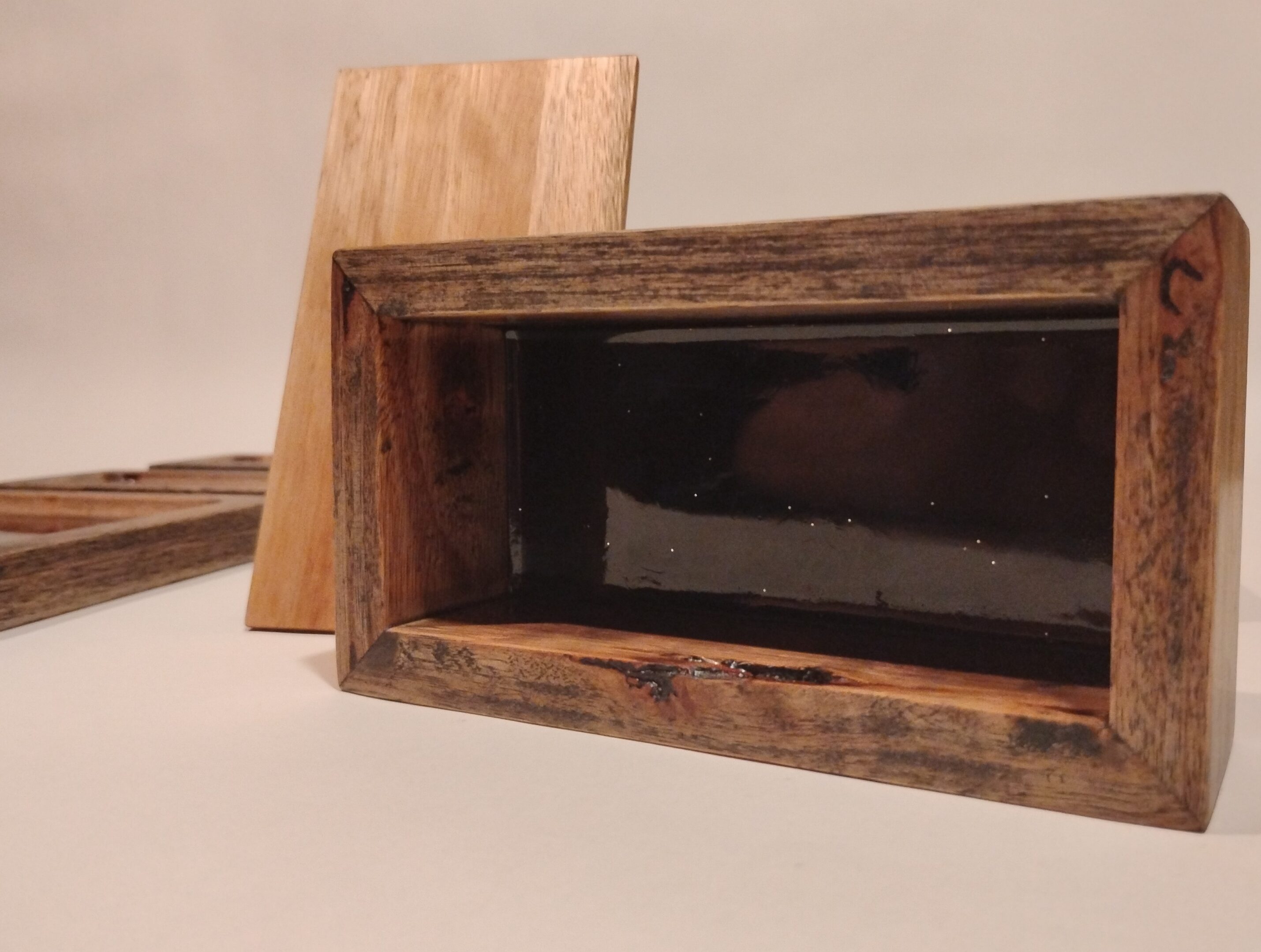 Two wooden boxes with distinct finishes placed on a white surface.