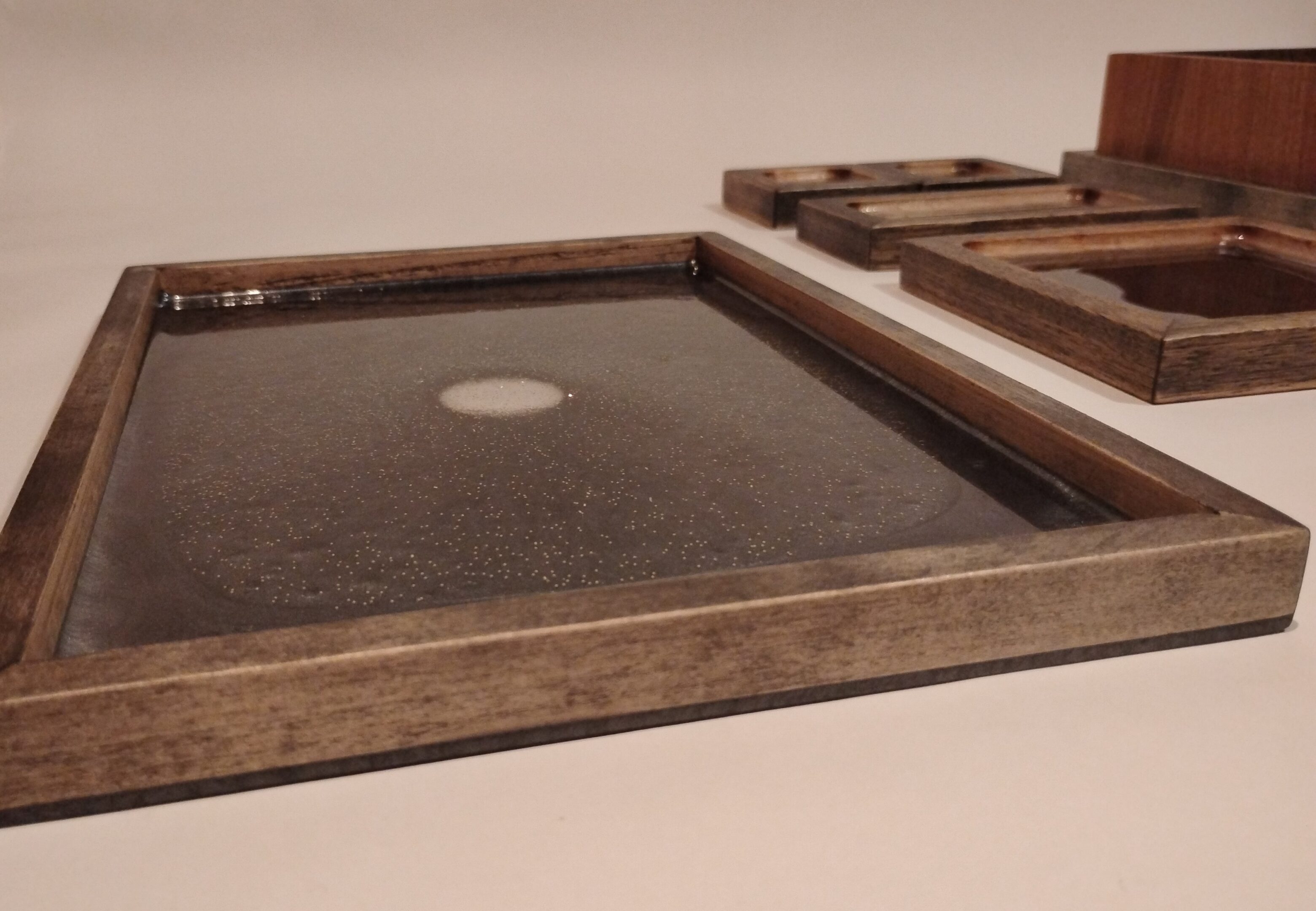 Close-up of a wooden frame with a dark textured surface.