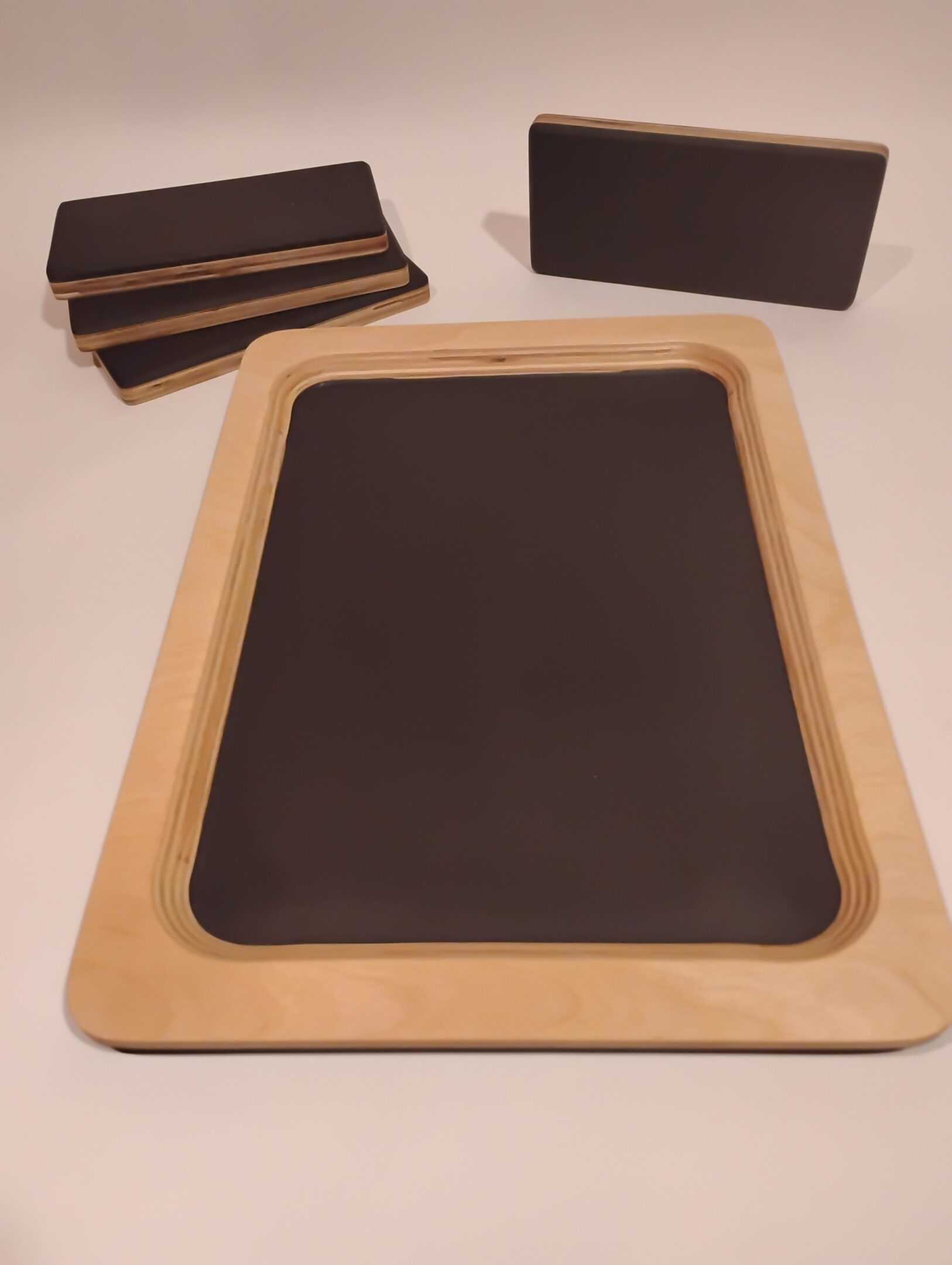Wooden-framed blackboard with wooden chalk holders beside it.
