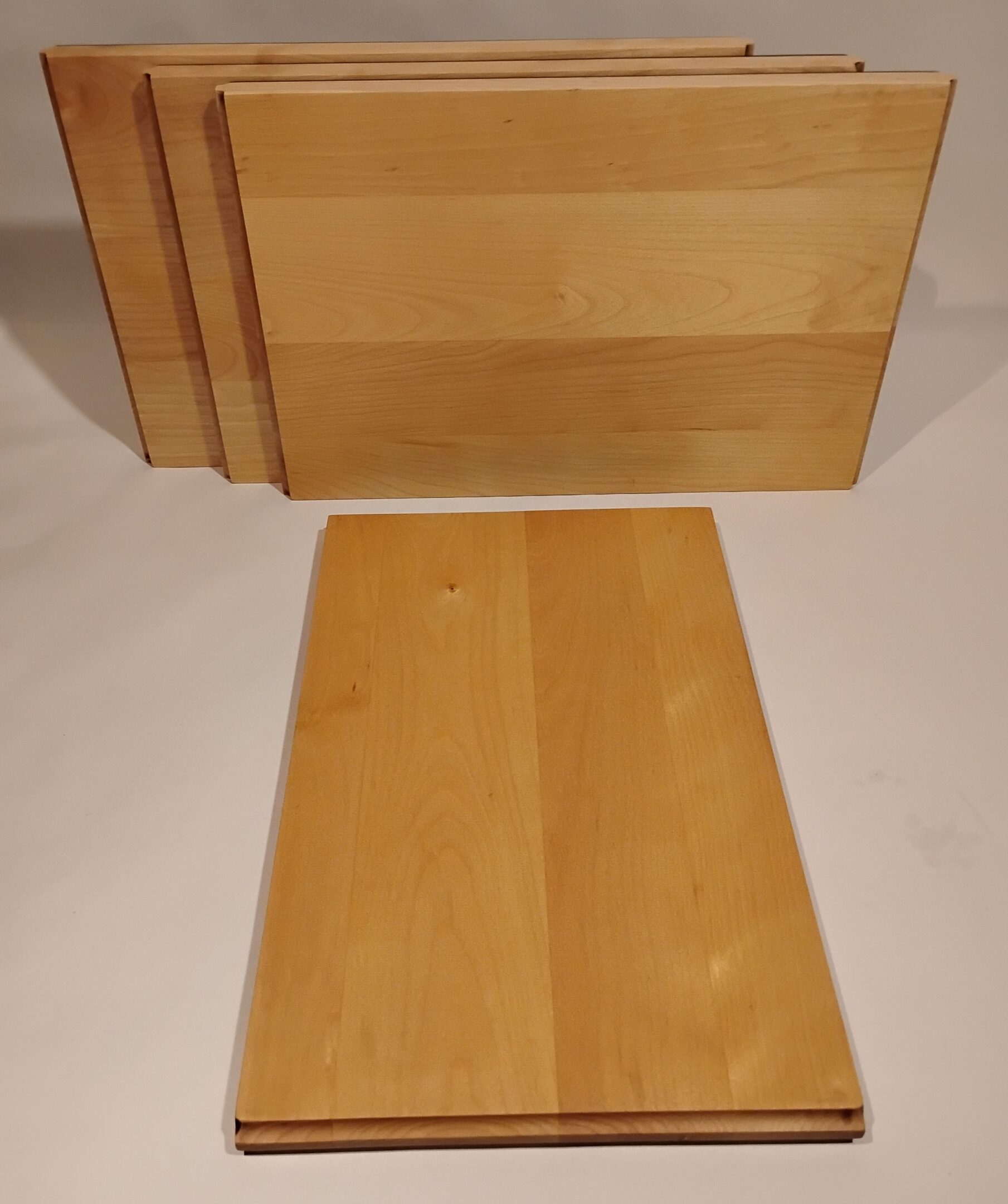 Two wooden panels leaning against a wall on a light floor.