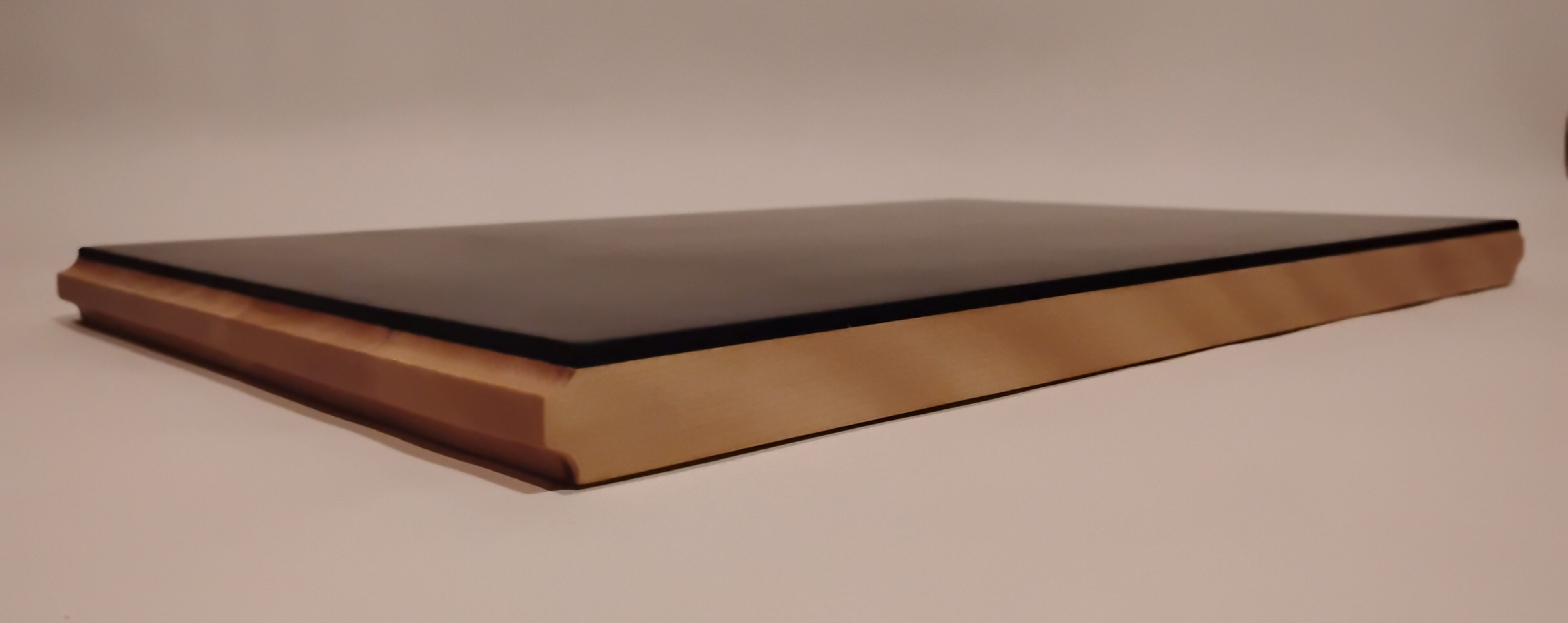 Closed book with a dark cover on a neutral background.