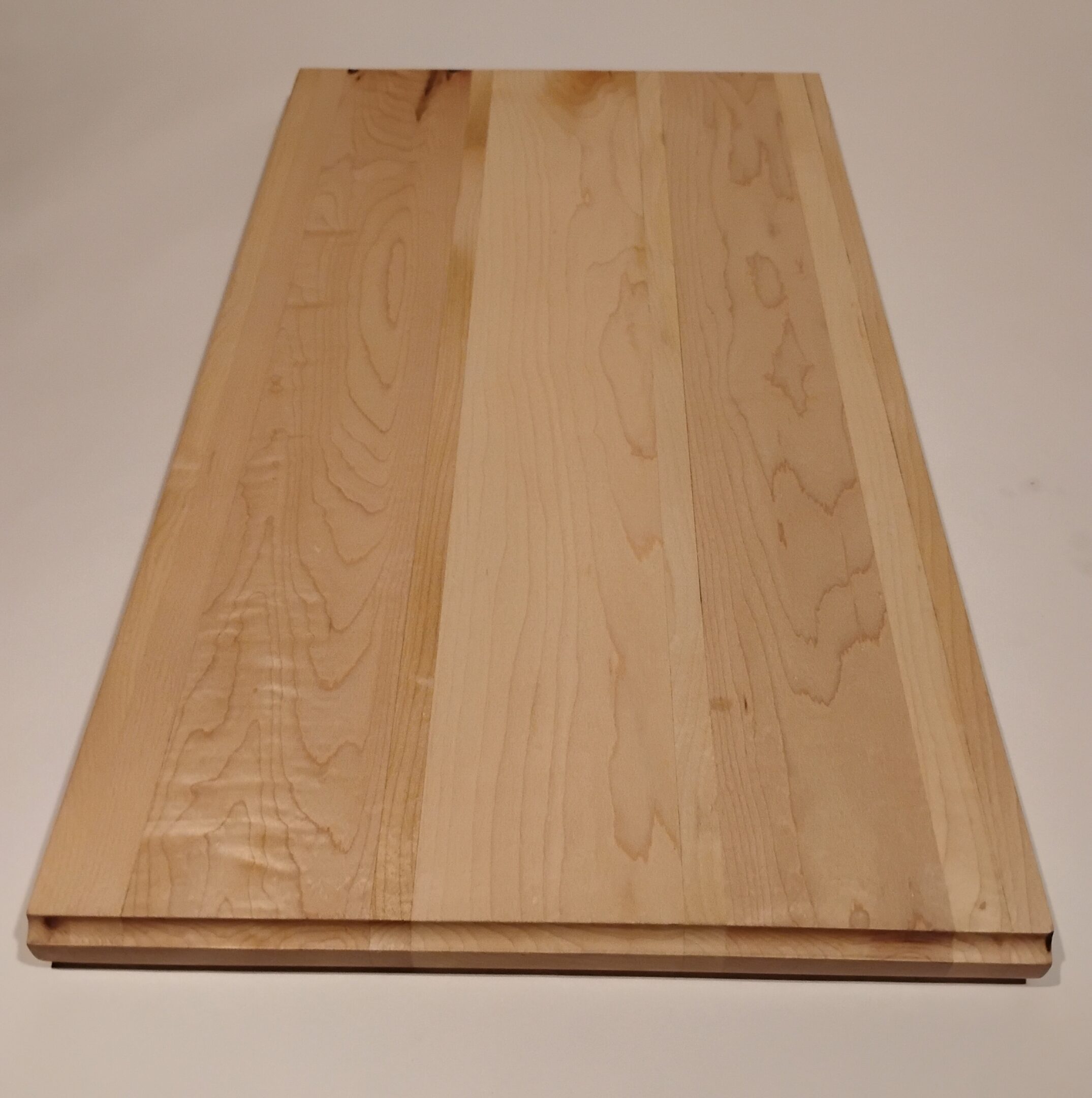 A polished wooden panel with a natural finish on a neutral background.