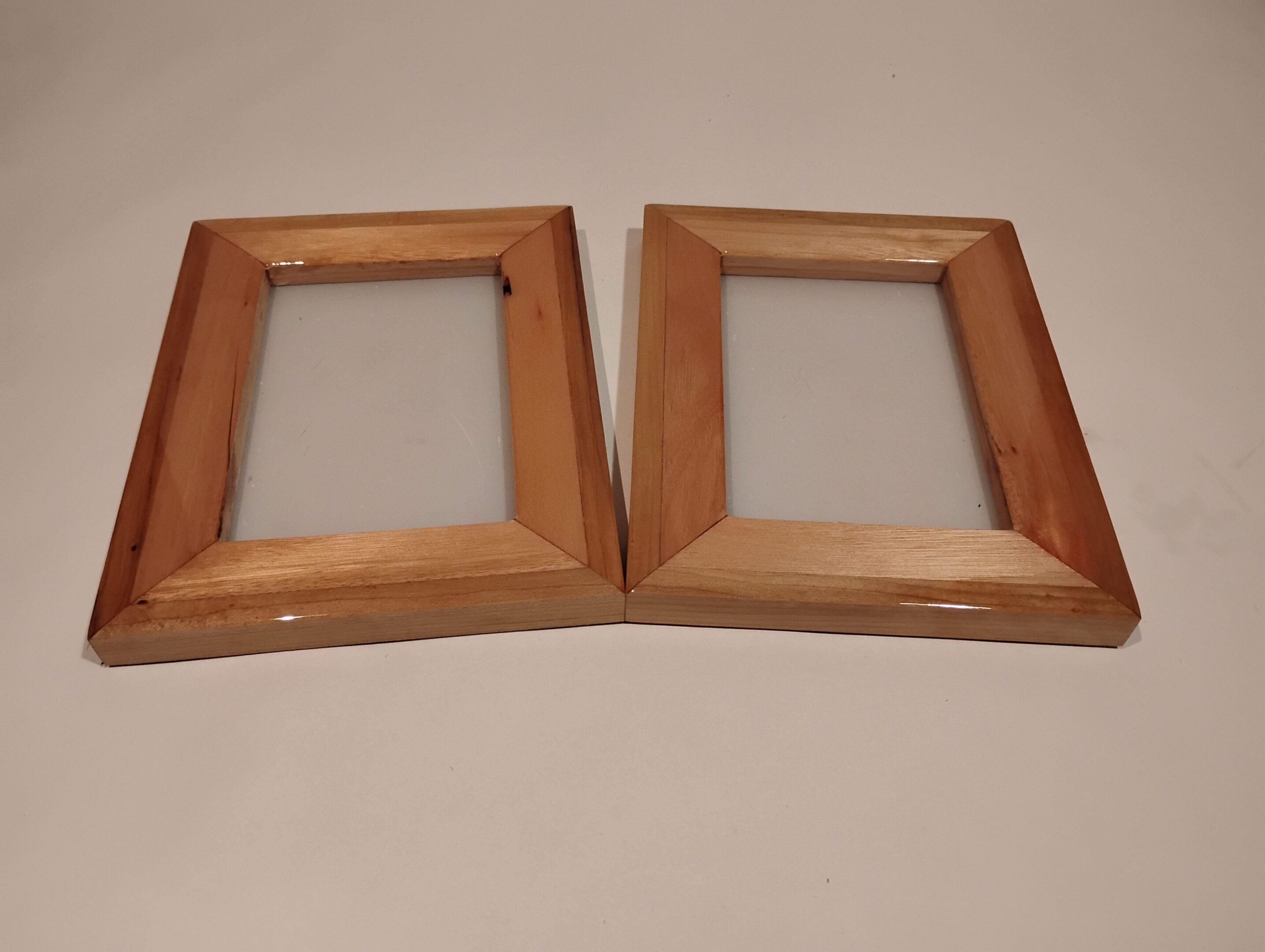 Two empty wooden picture frames with a natural finish.