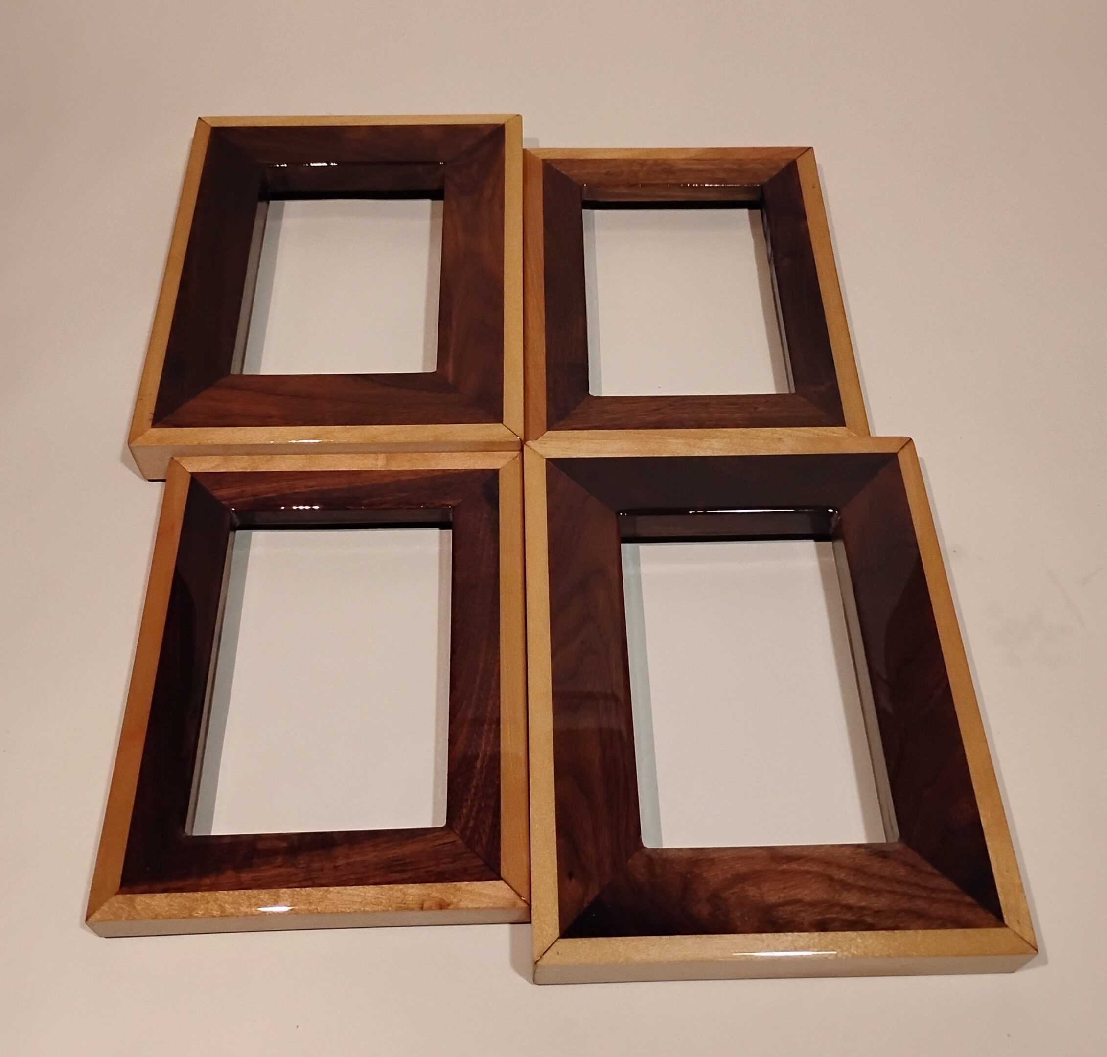Four empty wooden picture frames with a two-tone design.