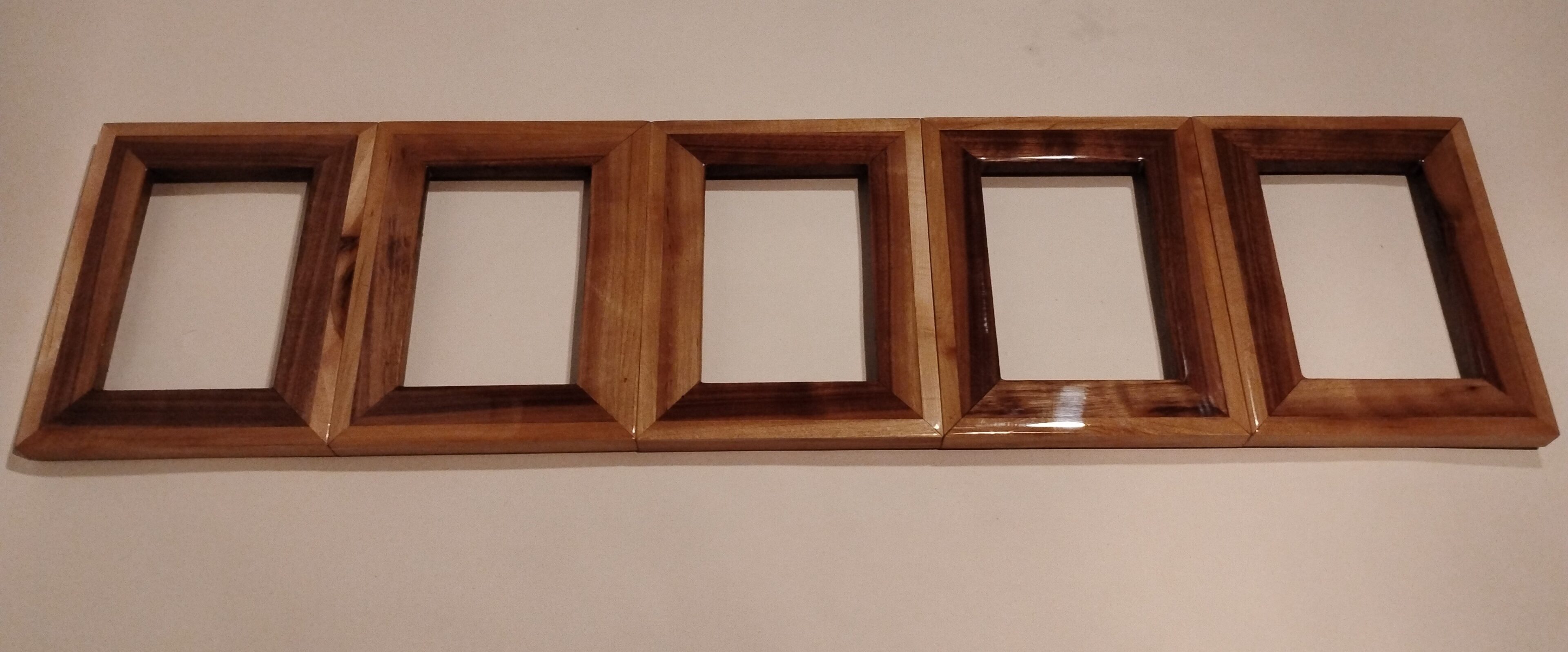 Wooden triple picture frame with a polished finish.