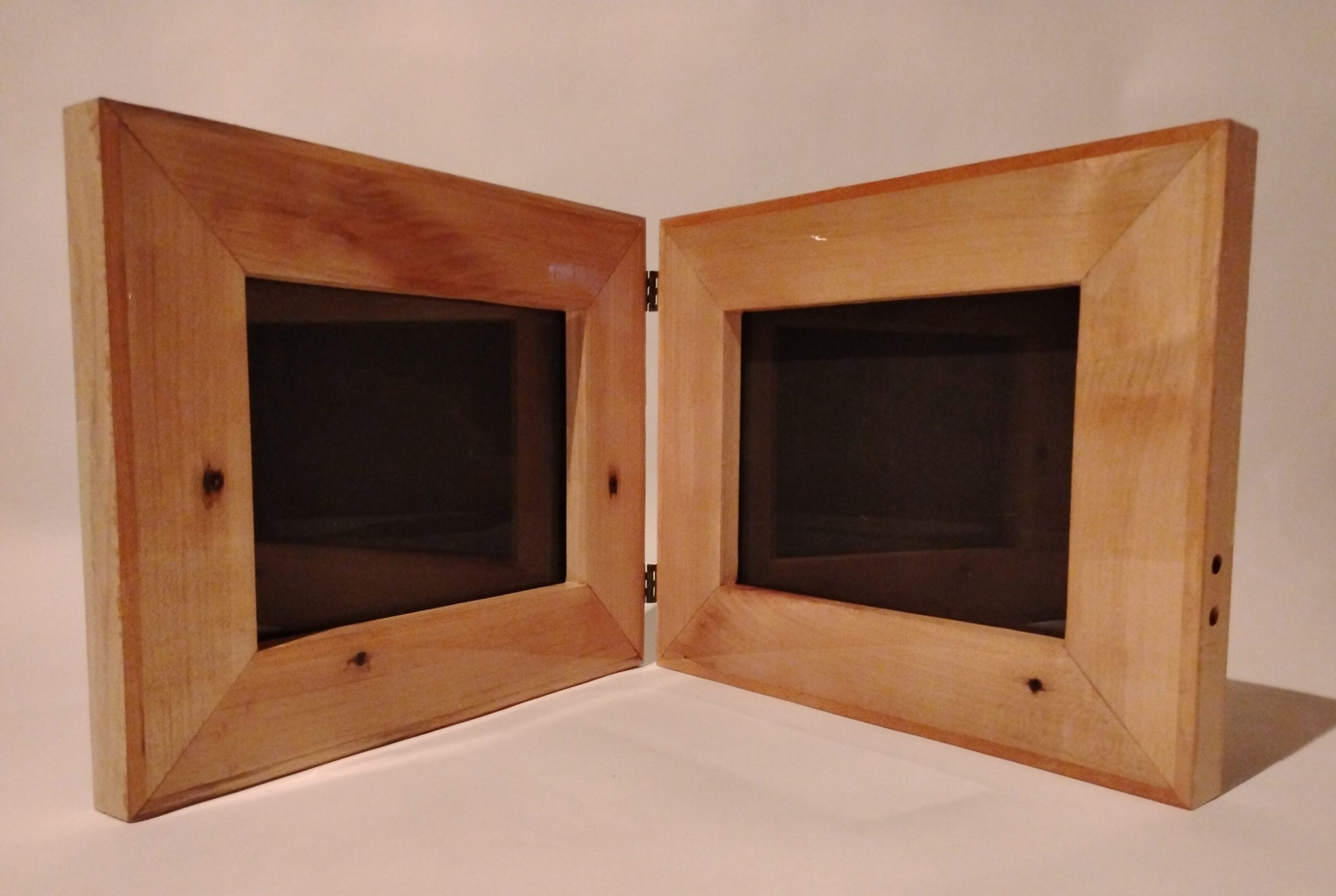 Wooden hinged frame with two empty black panels.