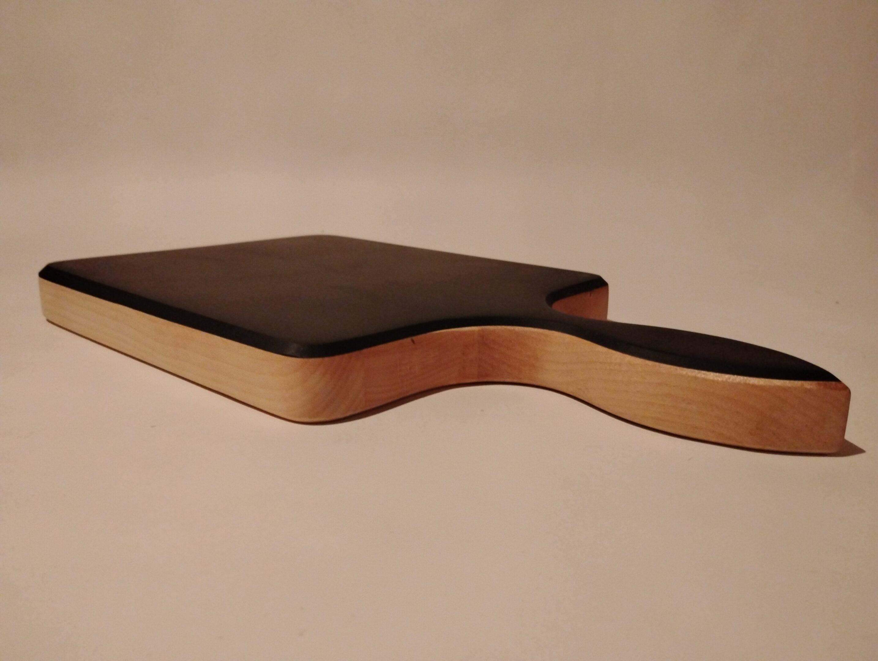 Close-up of a uniquely shaped wooden table with smooth curves.