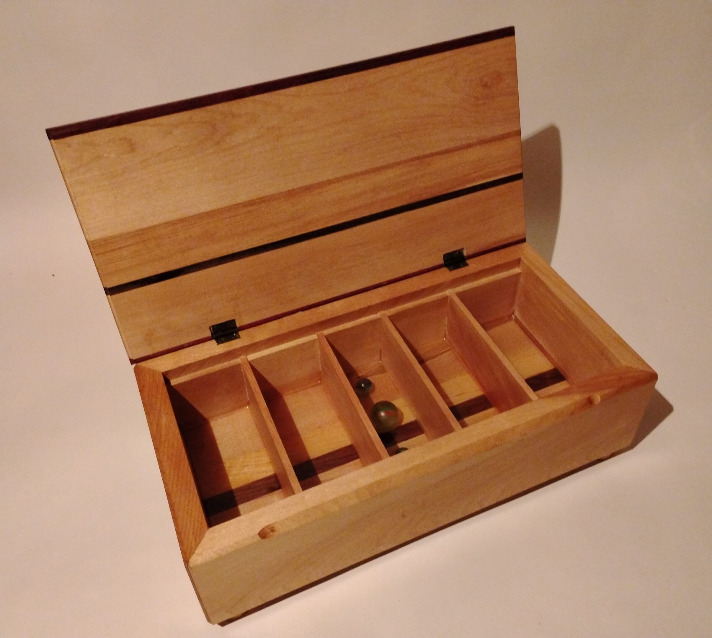 Wooden box with hinged lid and multiple compartments.