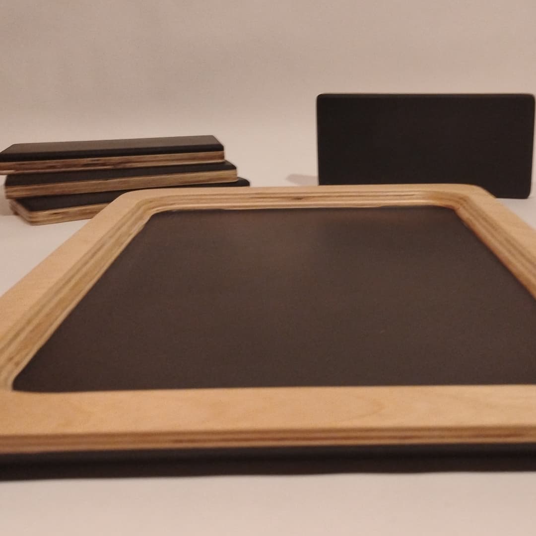 A wooden-framed chalkboard with erasers and a blackboard in the background.