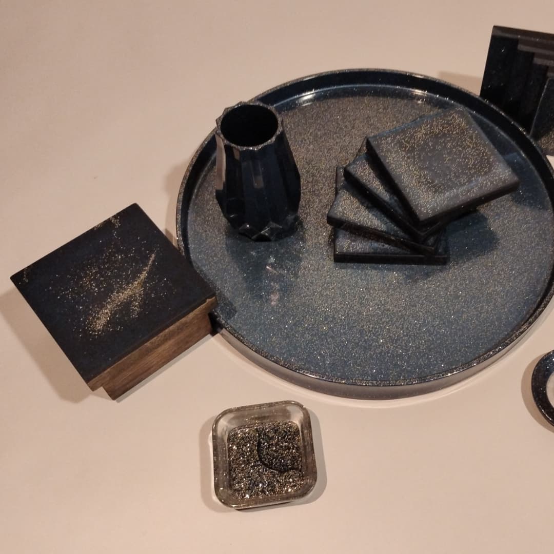 Elegant black ceramic tea set with tray and coasters.