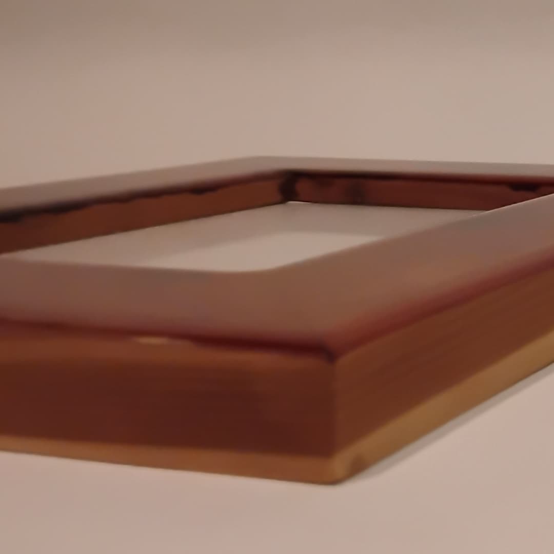 Close-up of a wooden picture frame with a glass front.