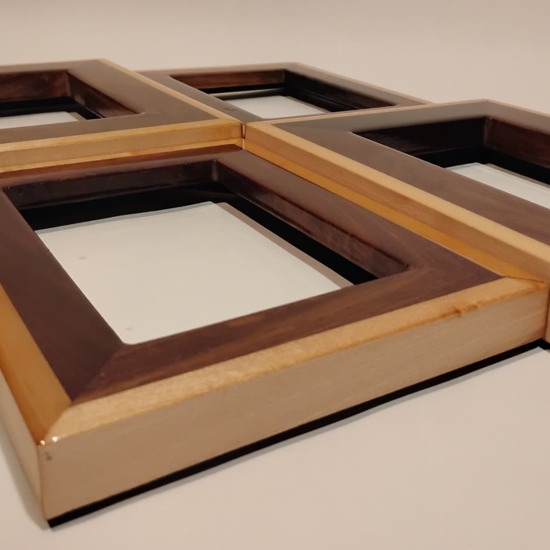 Four wooden picture frames arranged on a flat surface.
