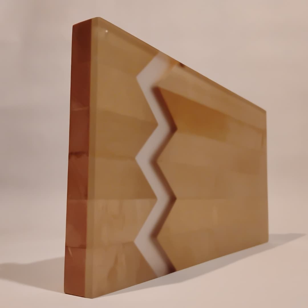 Wooden panel with zigzag white inlay design.