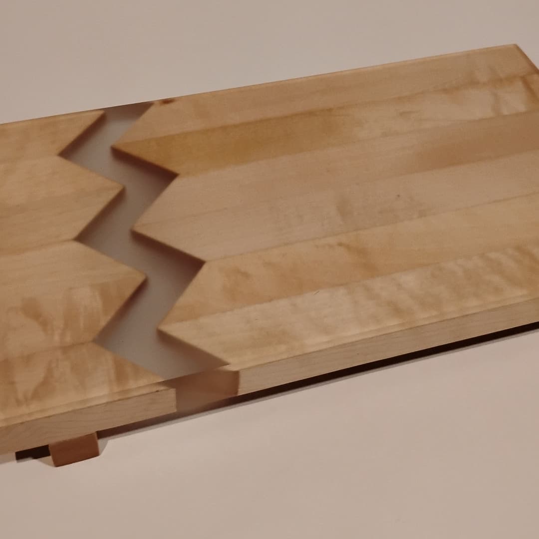 Wooden pieces with zigzag joints fitting together.