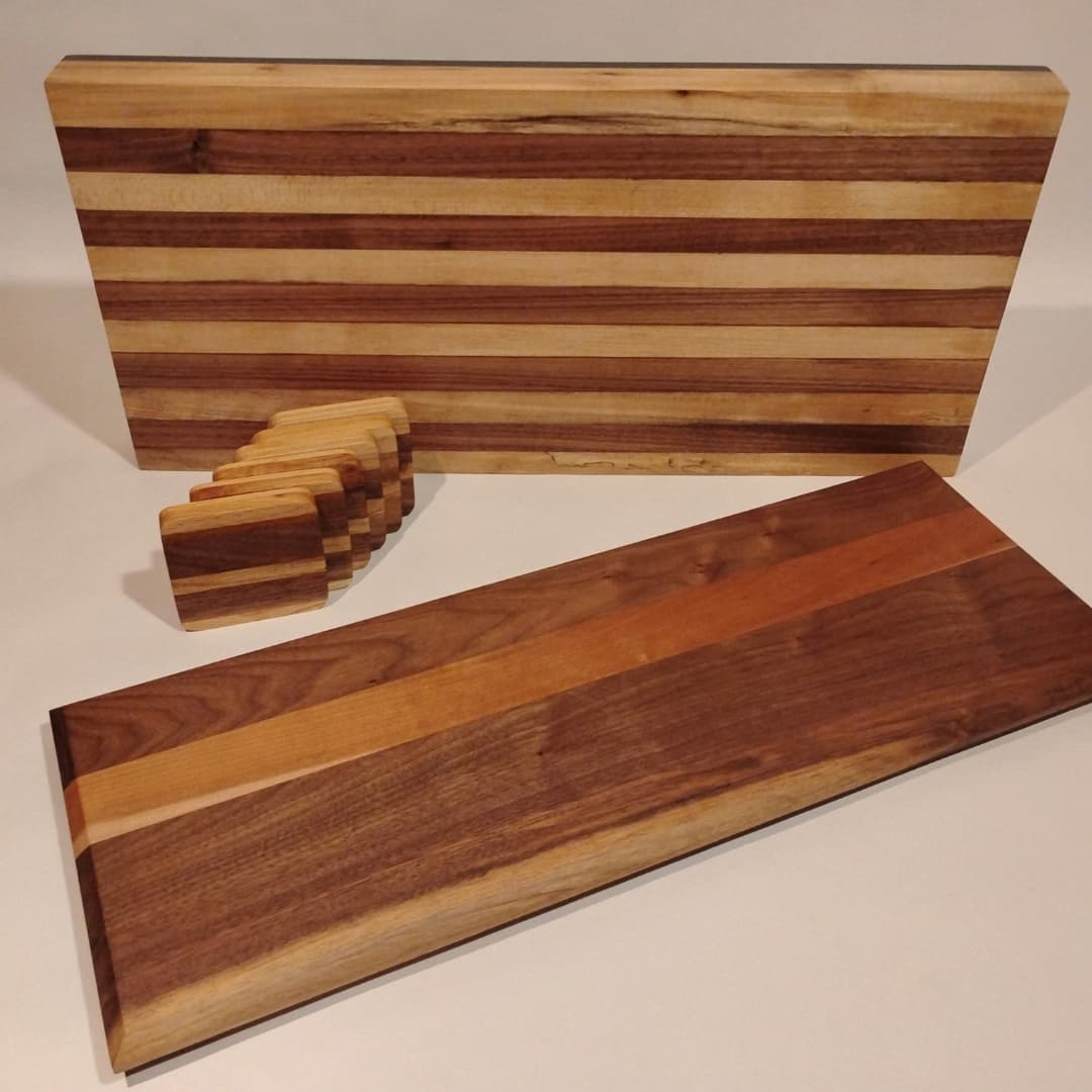 Two wooden cutting boards with striped patterns and a small stack of wooden coasters.