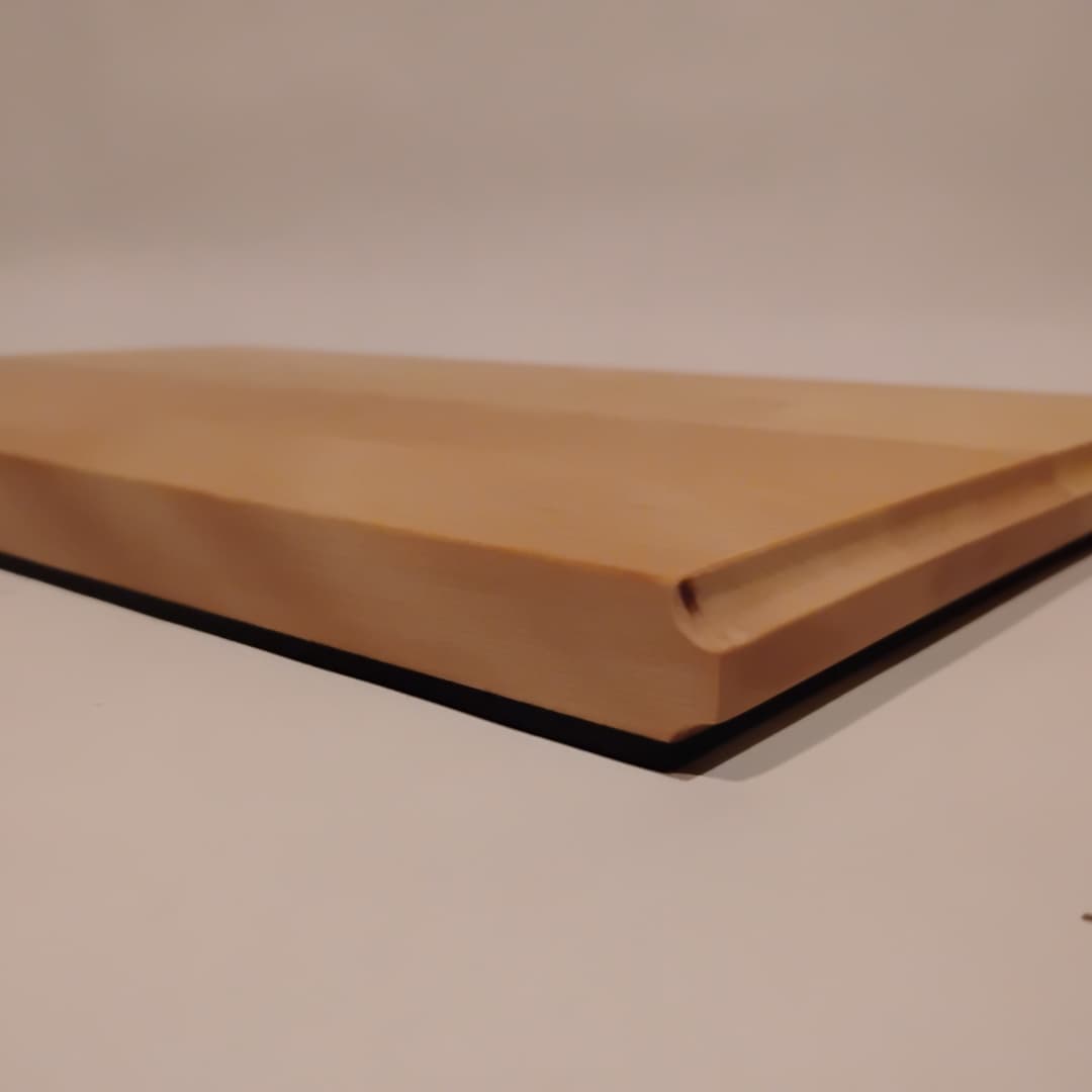 Close-up of a wooden board with a beveled edge on a white surface.