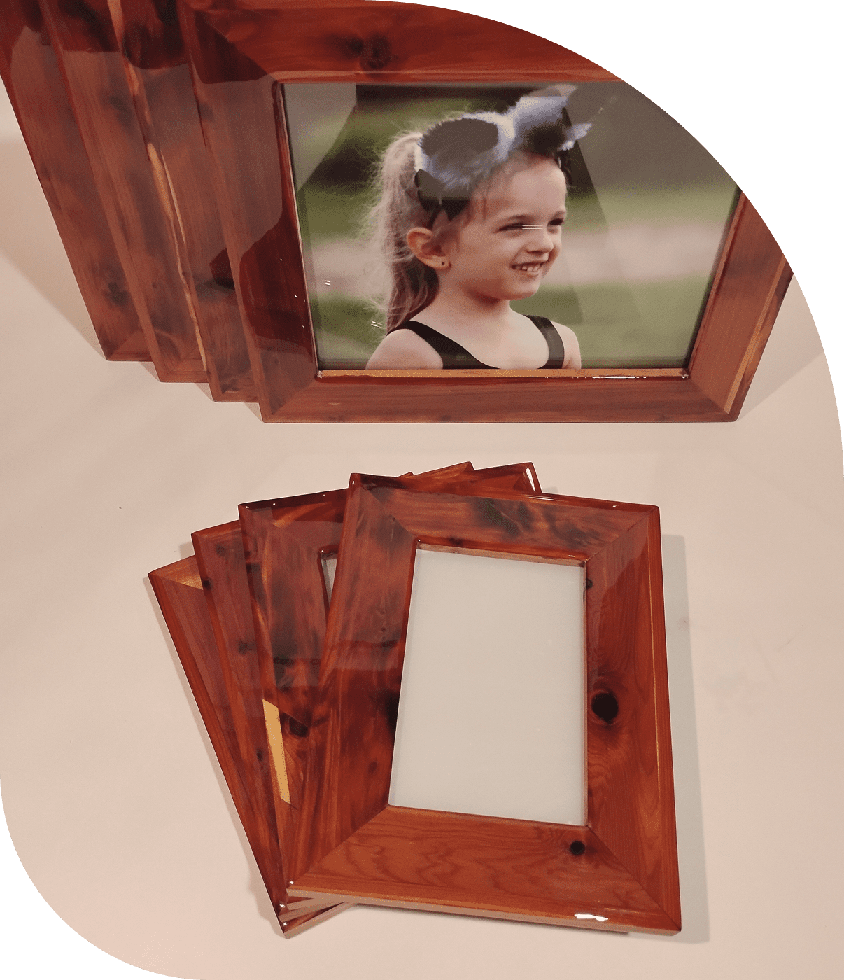 Stack of wooden photo frames with one frame displaying a child's photo.