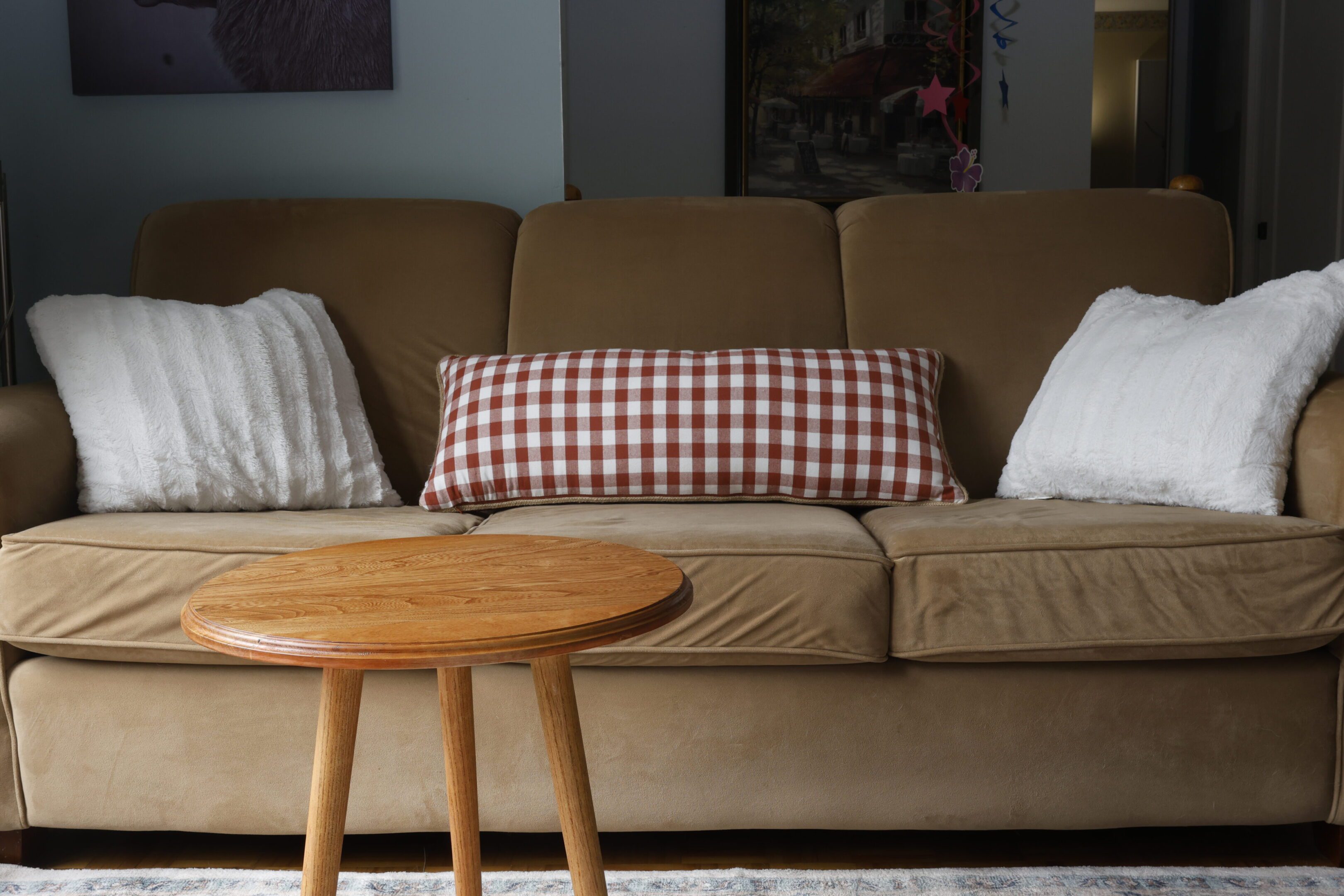Cozy living room with a brown sofa and wooden round table.