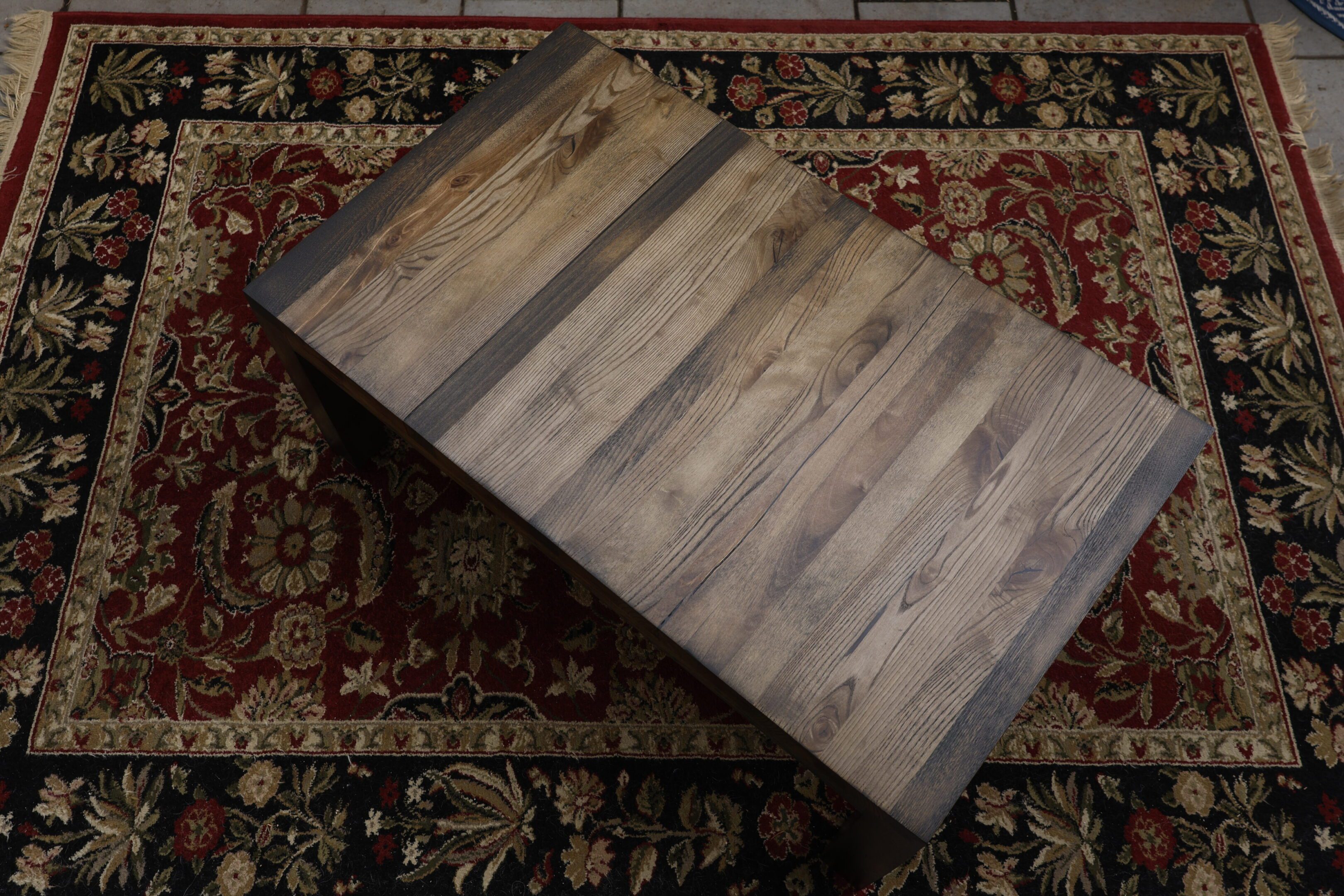 Rectangular wooden coffee table on a patterned rug.
